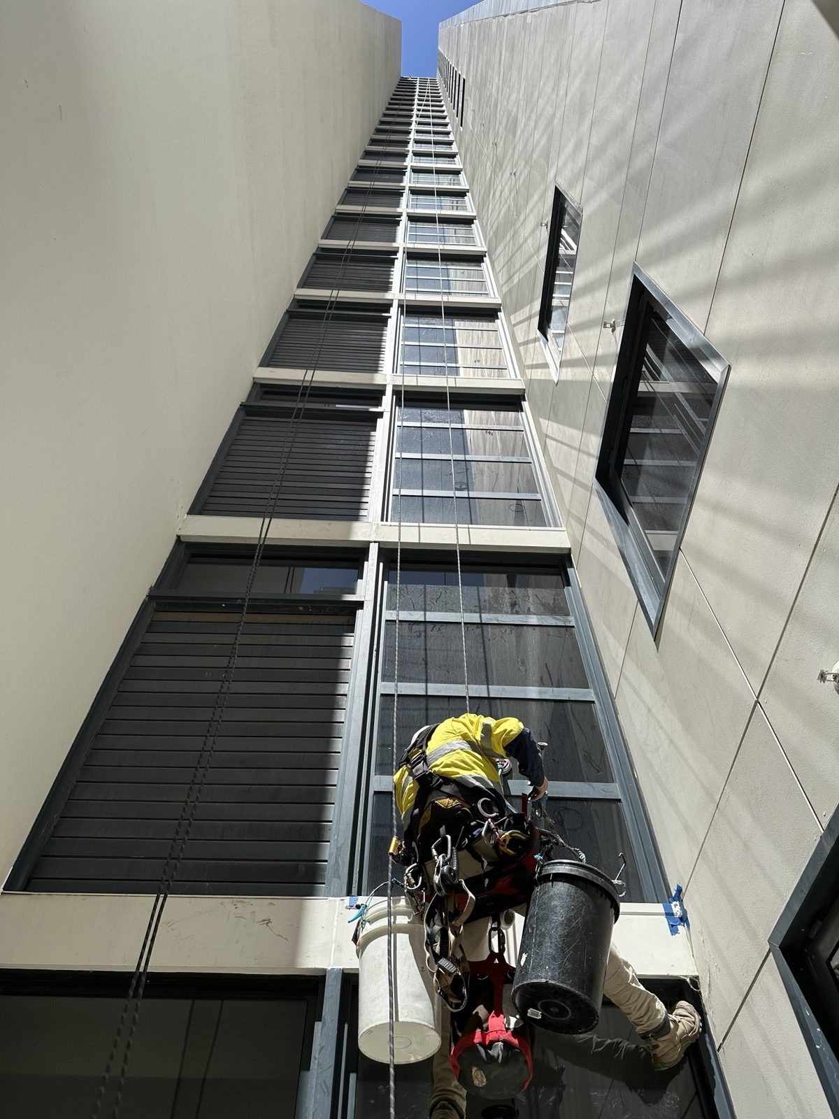Mission Possible rope access technician inspecting a high-rise building facade in Perth