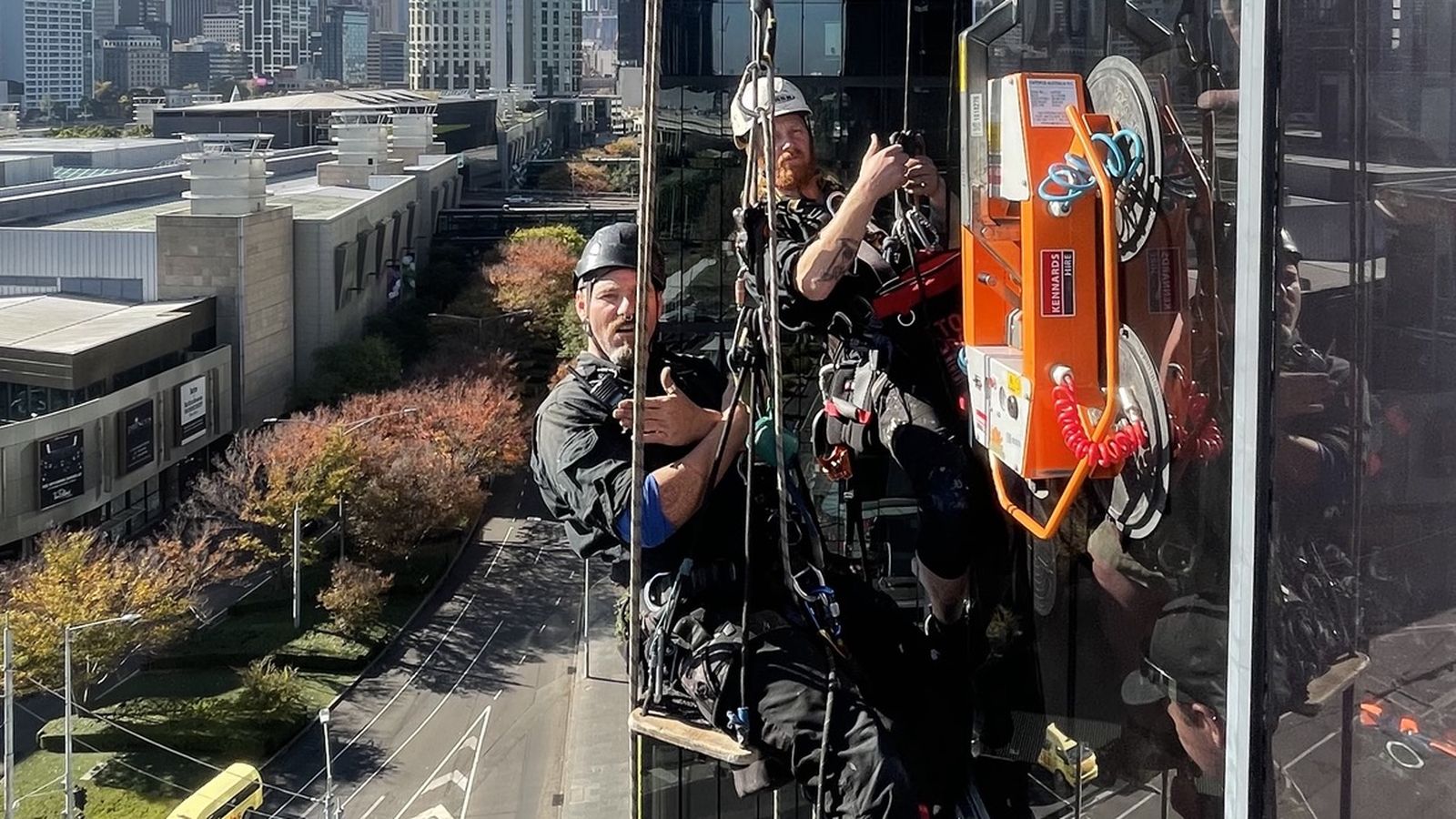 Mission Possible technicians performing general access rope work on a glass building facade